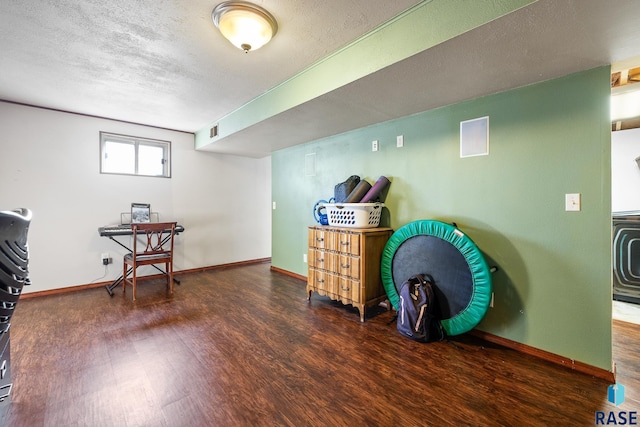 misc room featuring a textured ceiling and dark hardwood / wood-style flooring