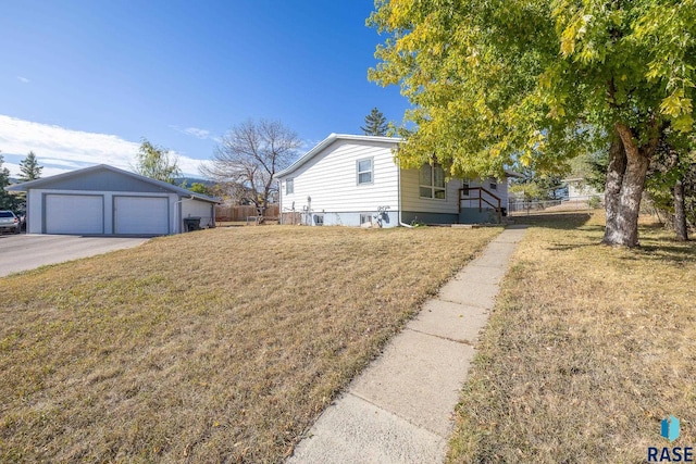 view of side of property featuring a yard, a garage, and an outbuilding