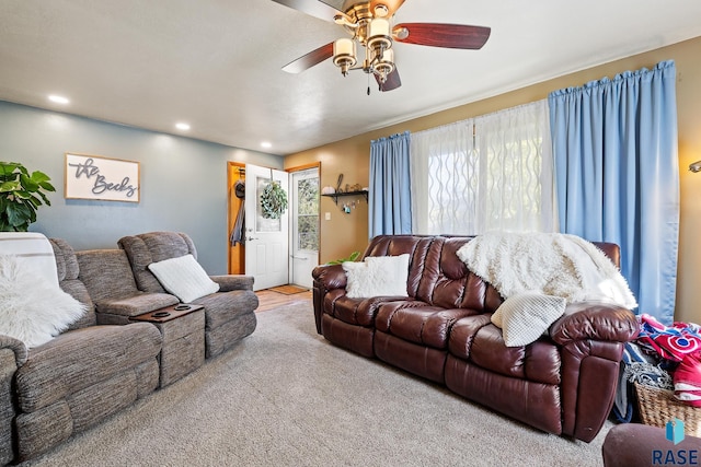 living room with light colored carpet, plenty of natural light, and ceiling fan