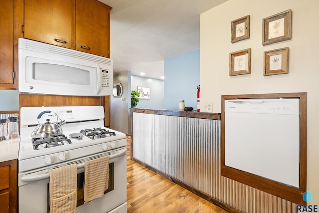 kitchen with light wood-type flooring and white appliances