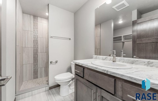 bathroom with toilet, walk in shower, and vanity