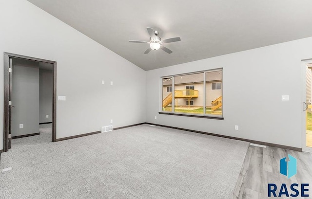 spare room featuring vaulted ceiling, light carpet, and ceiling fan