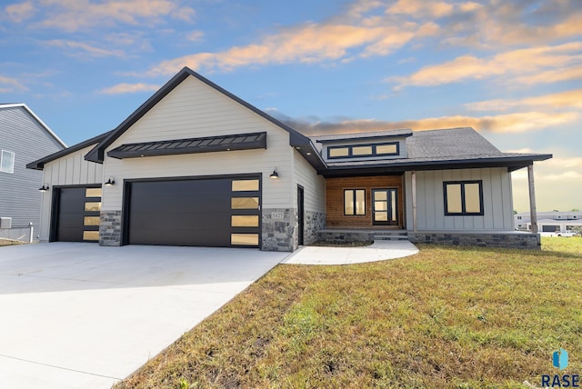 modern farmhouse style home featuring a garage and a lawn