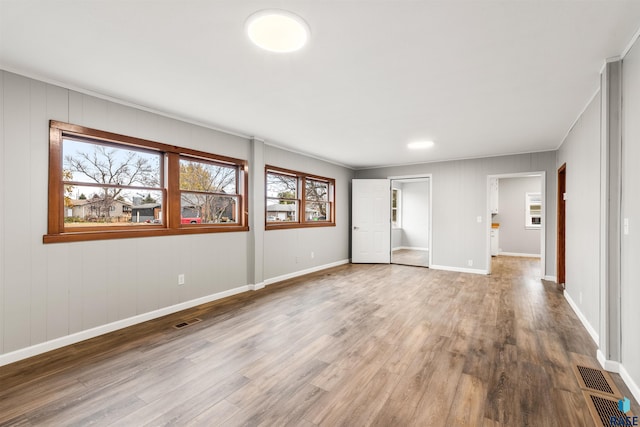 empty room featuring ornamental molding and hardwood / wood-style floors