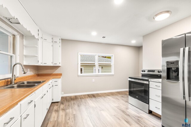 kitchen featuring sink, white cabinetry, light hardwood / wood-style flooring, and stainless steel appliances