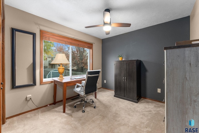 carpeted home office featuring ceiling fan and a textured ceiling