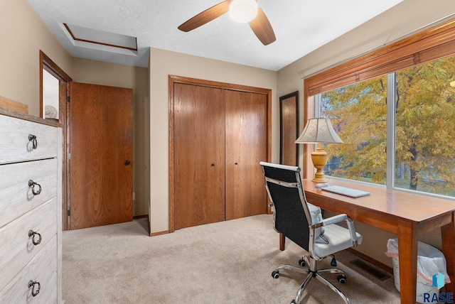 unfurnished office featuring ceiling fan and light colored carpet