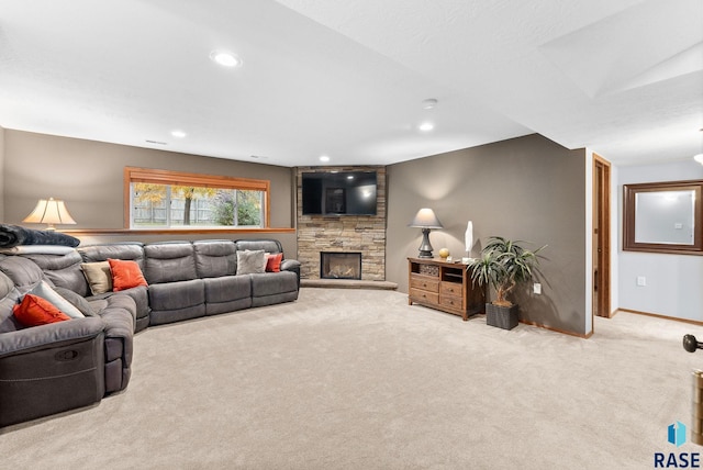 carpeted living room featuring a stone fireplace