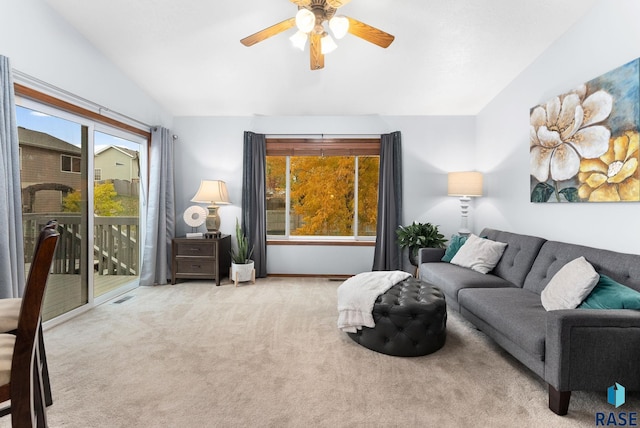 living room featuring vaulted ceiling, light colored carpet, and plenty of natural light