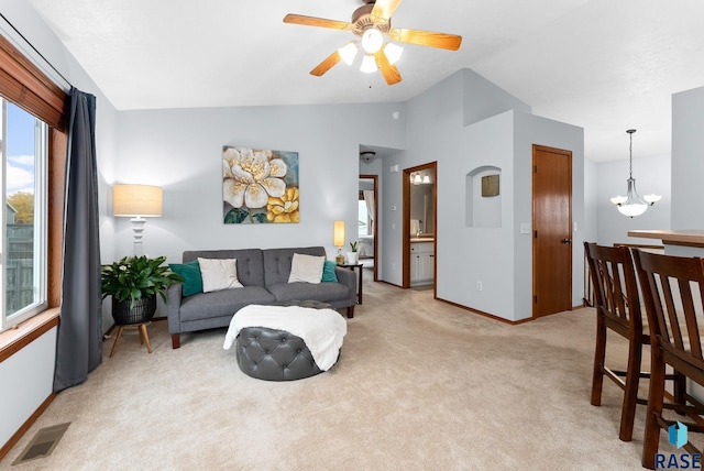 living room with light carpet, lofted ceiling, and ceiling fan with notable chandelier