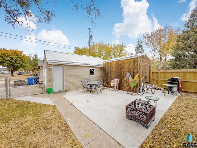 view of patio with a storage unit and an outdoor fire pit