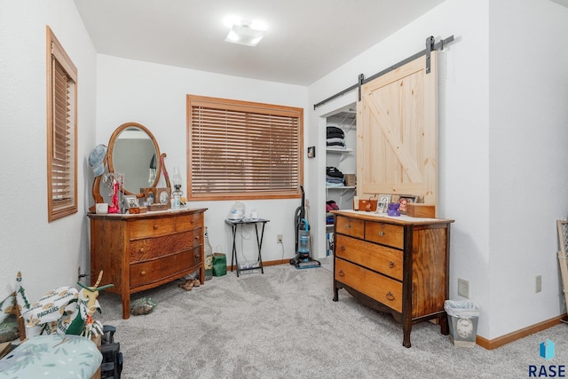 carpeted bedroom with a closet and a barn door