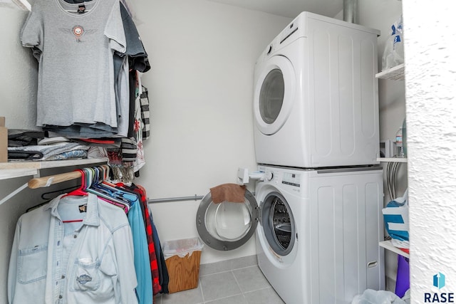 clothes washing area featuring stacked washer and dryer and light tile patterned floors