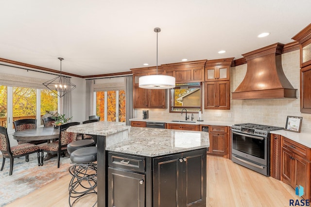 kitchen featuring a center island, appliances with stainless steel finishes, a wealth of natural light, and premium range hood