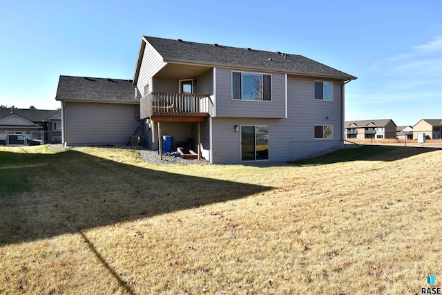 rear view of property with a yard and a balcony