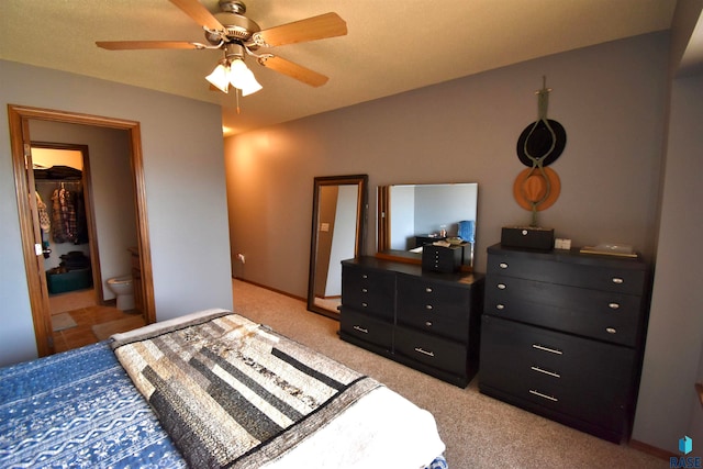 bedroom featuring light carpet, a textured ceiling, connected bathroom, and ceiling fan