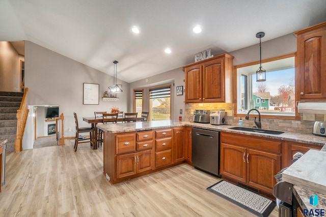 kitchen with kitchen peninsula, tasteful backsplash, hanging light fixtures, vaulted ceiling, and dishwasher