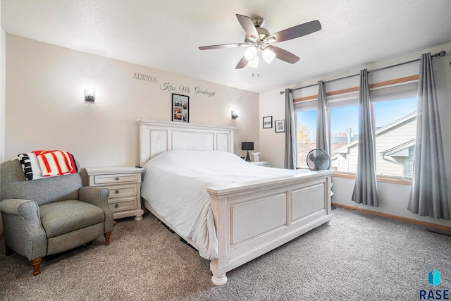 carpeted bedroom featuring ceiling fan and a textured ceiling