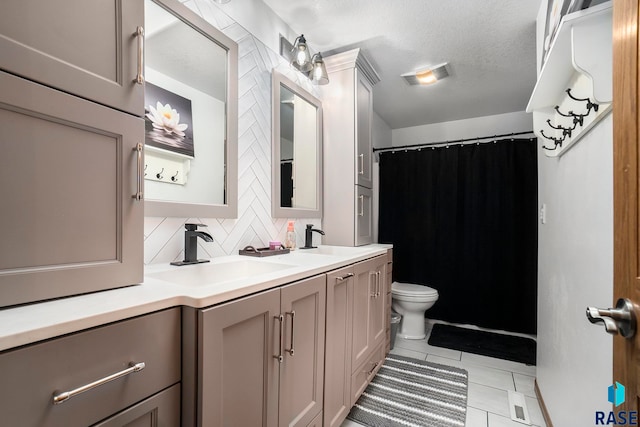 bathroom featuring decorative backsplash, a textured ceiling, toilet, vanity, and tile patterned floors