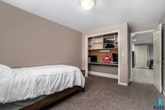 bedroom with a closet, a textured ceiling, and dark colored carpet