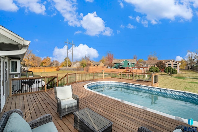 view of swimming pool featuring a wooden deck and a lawn