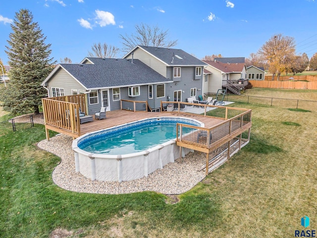 view of pool featuring a deck and a lawn