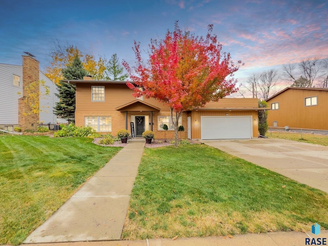 view of front of house featuring a garage, cooling unit, and a lawn