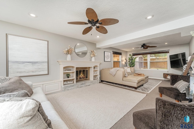 living room featuring a textured ceiling, carpet, and ceiling fan