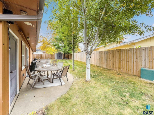 view of yard featuring a shed and a patio area