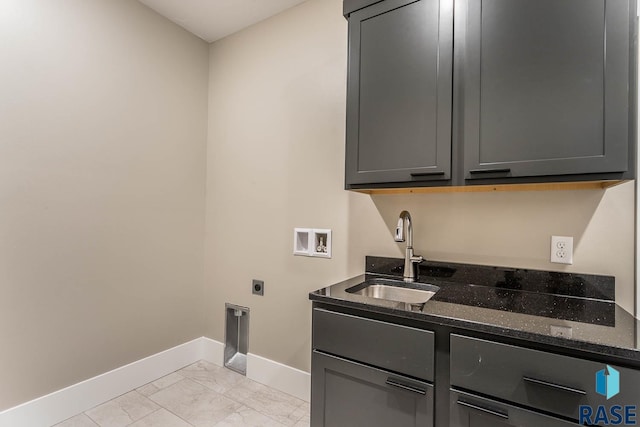 clothes washing area with hookup for an electric dryer, hookup for a washing machine, cabinets, and sink