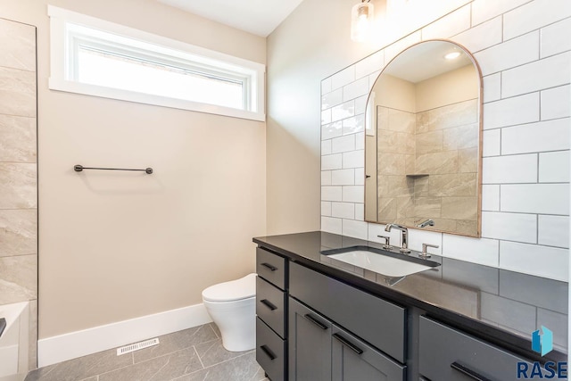 bathroom with tile patterned flooring, vanity, toilet, and a tub to relax in