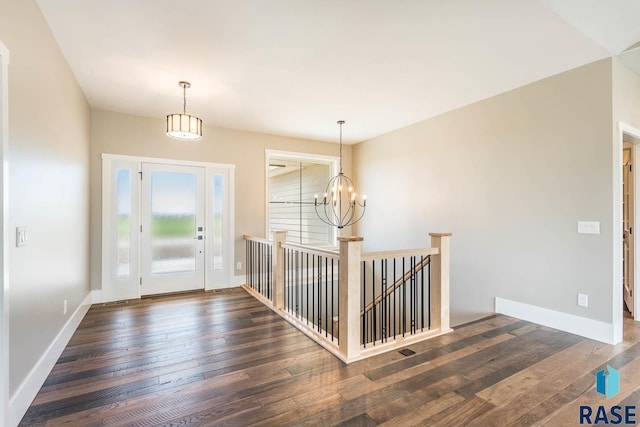 foyer entrance featuring a chandelier and dark wood-type flooring