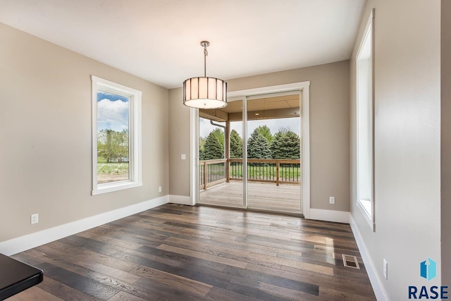 unfurnished dining area featuring dark hardwood / wood-style flooring