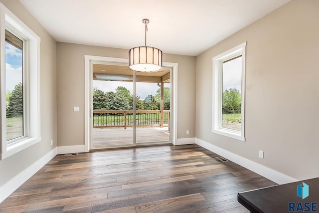 unfurnished dining area featuring dark wood-type flooring