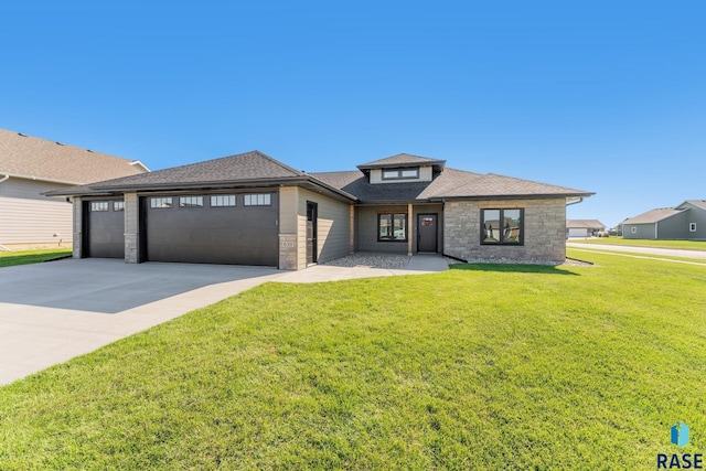 prairie-style house featuring a garage and a front lawn