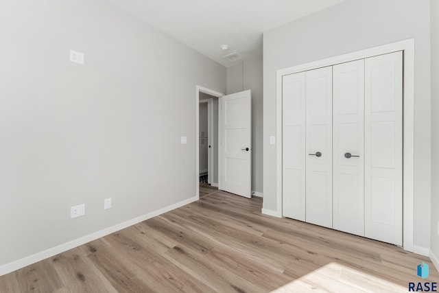 unfurnished bedroom featuring a closet and light wood-type flooring