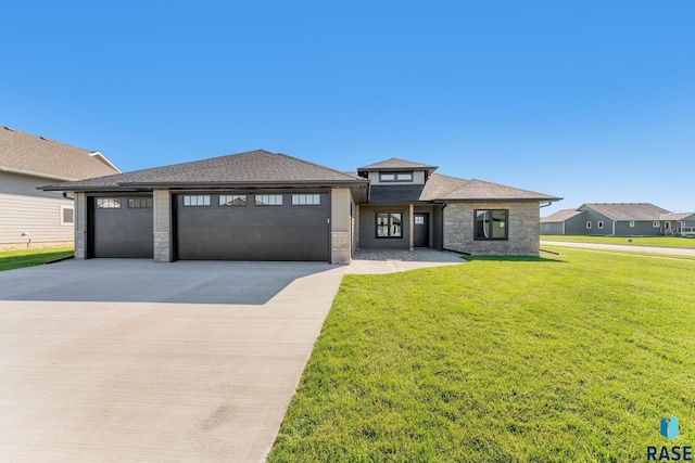 prairie-style home with a front lawn and a garage