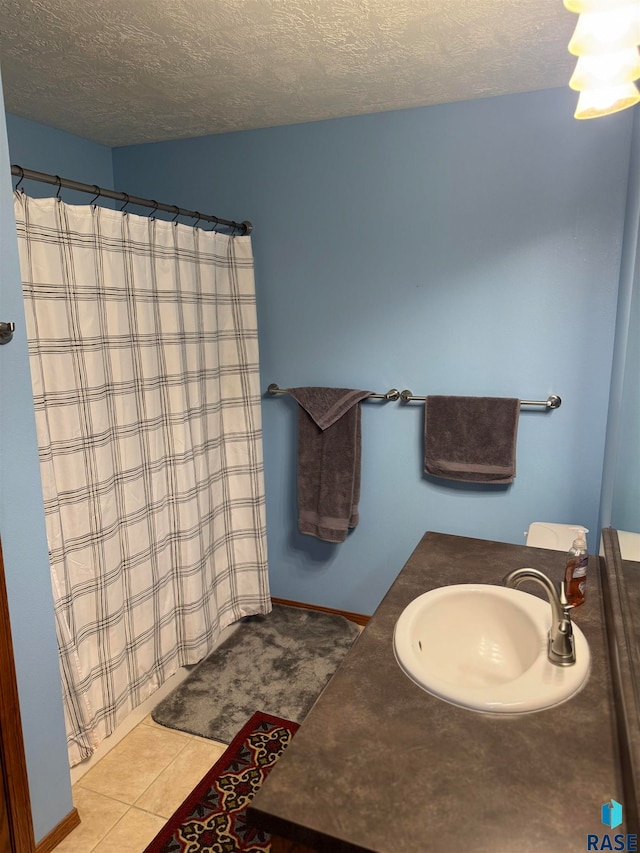 bathroom with vanity, a textured ceiling, and tile patterned floors