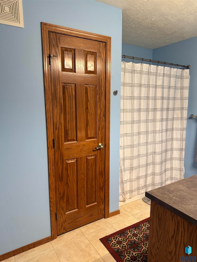 bathroom featuring vanity, a textured ceiling, and tile patterned flooring