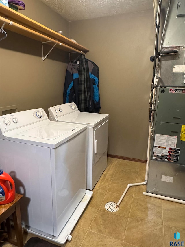 washroom with separate washer and dryer, heating unit, light tile patterned flooring, and a textured ceiling