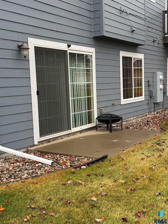 property entrance featuring a patio and a lawn