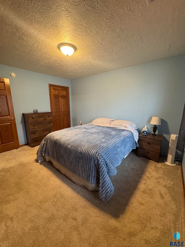 carpeted bedroom featuring a textured ceiling