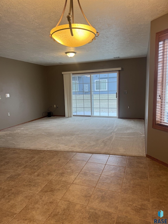 carpeted empty room with a textured ceiling