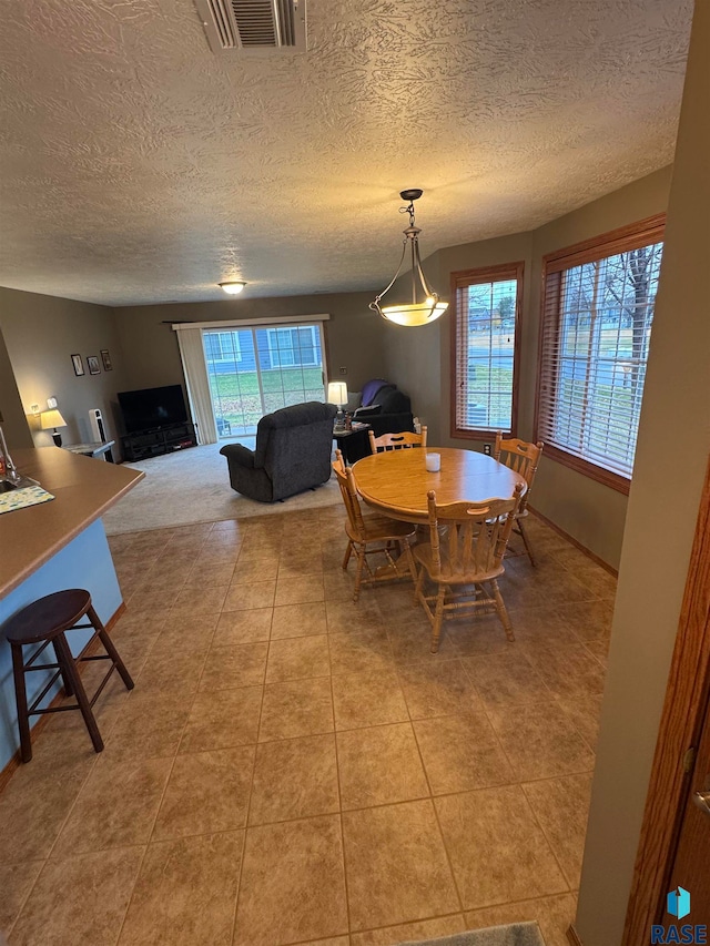 tiled dining room with a textured ceiling