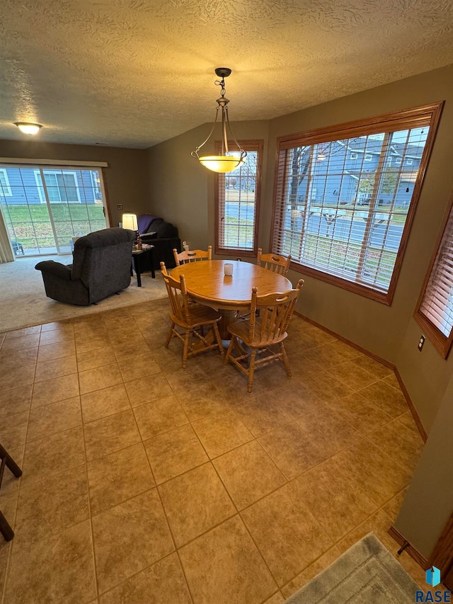 dining space with light tile patterned floors and a textured ceiling