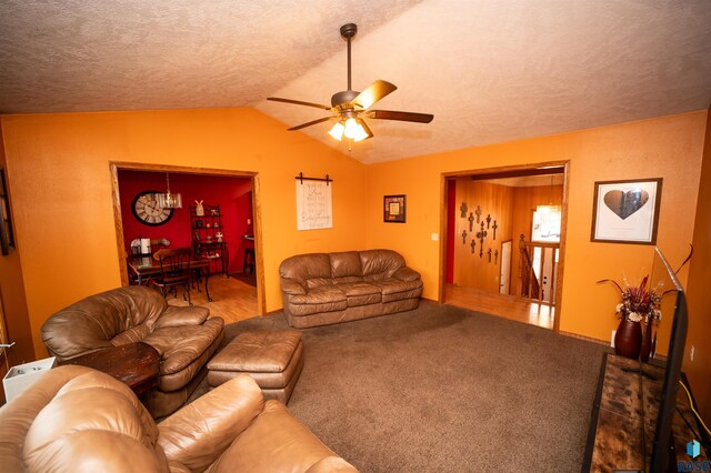 living area with vaulted ceiling, a textured ceiling, ceiling fan, and carpet floors