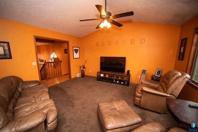 living area featuring lofted ceiling, a ceiling fan, carpet floors, and a textured ceiling