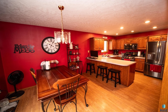 dining area with baseboards, an inviting chandelier, recessed lighting, a textured ceiling, and light wood-type flooring