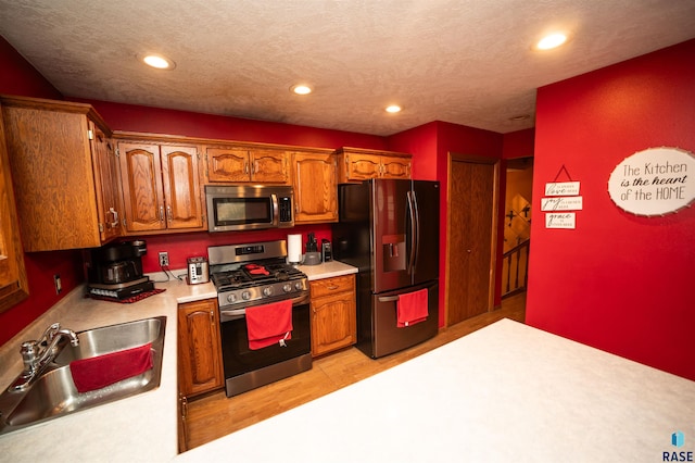 kitchen with brown cabinets, a sink, recessed lighting, stainless steel appliances, and light countertops