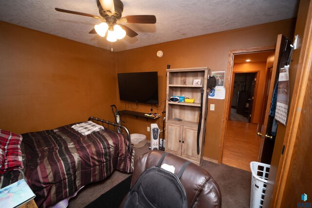 carpeted bedroom with a textured ceiling and ceiling fan